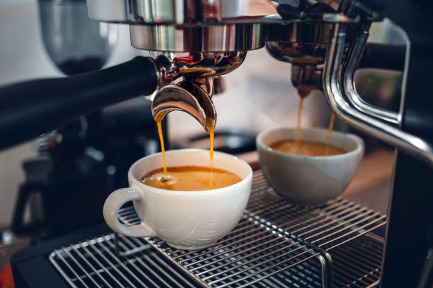 istock Espresso coffee extraction from a professional coffee machine with a bottomless filter, Close-up of a coffee drop  from the coffee machine 1489579545