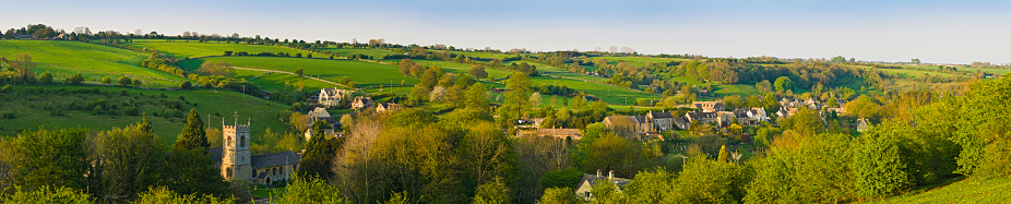 Traditional stone church, cottages, farmhouses and homes nestled in a tranquil patchwork landscape of gently rolling hills and verdant pasture in this bucolic pastoral panorama. ProPhoto RGB profile for maximum color fidelity and gamut.