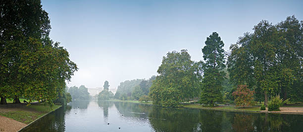Early morning mist rising over the lake reflecting Buckingham Palace, the leafy foliage and tranquil banks of St. James' Park in the heart of London, UK. ProPhoto RGB profile for maximum color fidelity and gamut.