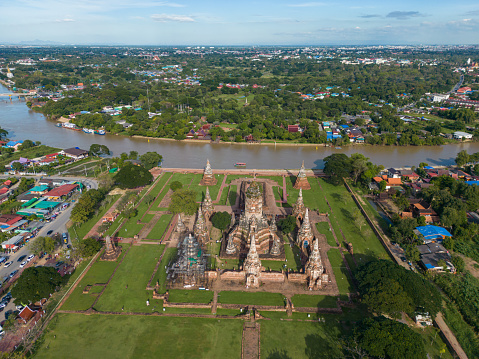 Aerial view evening sunset at Wat Chaiwatthanaram green grass park famous ruin temple with Chao Phraya river in Ayutthaya, Thailand