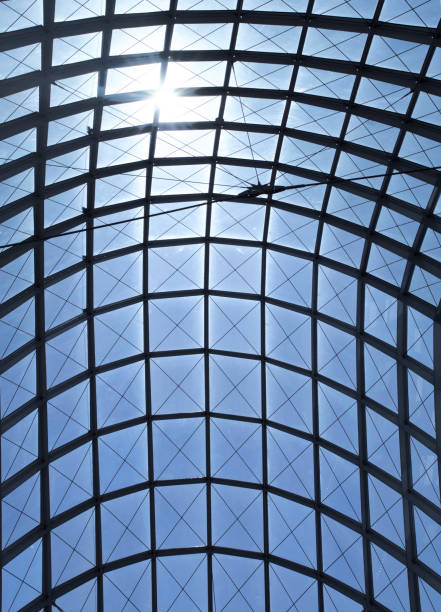istock architecture detail pattern with the sun in a blue sky above a glass ceiling, vertical 1489610507