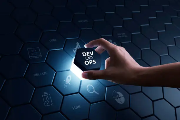 Hand of human putting hexagon piece to full fill the part of software development and IT operation, Agile programming technology and DevOps concept.