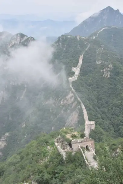 Photo of clouds billowing over a section of the great wall of china