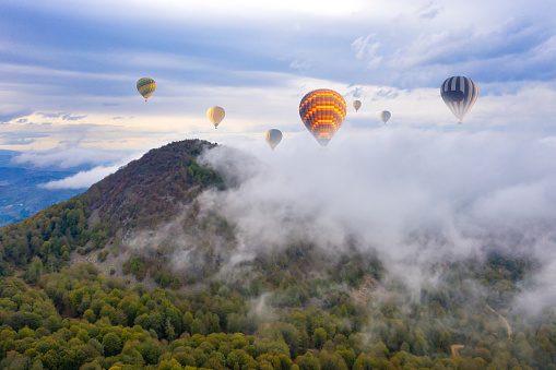 Scenic summer landscape with hot air balloon, forest and mountains.