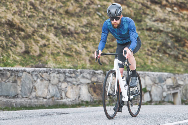 istock Man cyclist on road climbs 1489643417