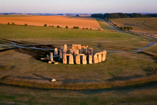 Aerial view to Stonehenge prehistoric megalith monument arranged in circle at sunrise.