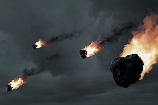3D rendering of falling fireball meteors in front of overcast sky