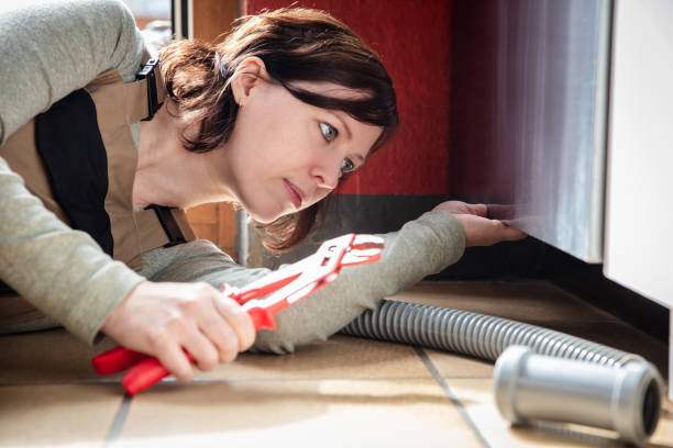 istock female plumber installs or repairs a dishwasher 1489654457