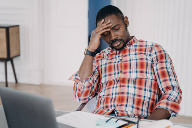 istock Tired african american man suffer headache at laptop thinking about business problem. Stress at work 1489656214