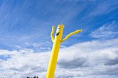 Inflatable wind doll against cloudy sky background.