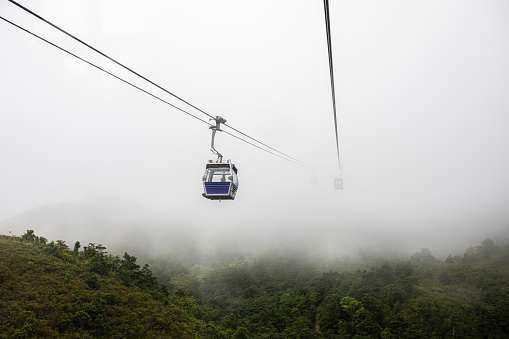 ngong ping 360 cable car on the green mountain landscape view in the rain season hong Kong aerial view