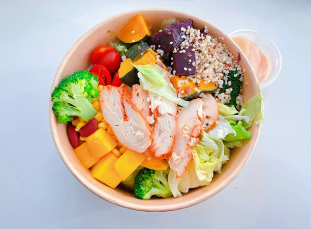 istock Salad bowl with chicken and vegetables from high angle view on white background editable 1489664113