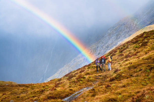 istock Fantastic view of hikers and rainbow on dramatic sky. 1489666839
