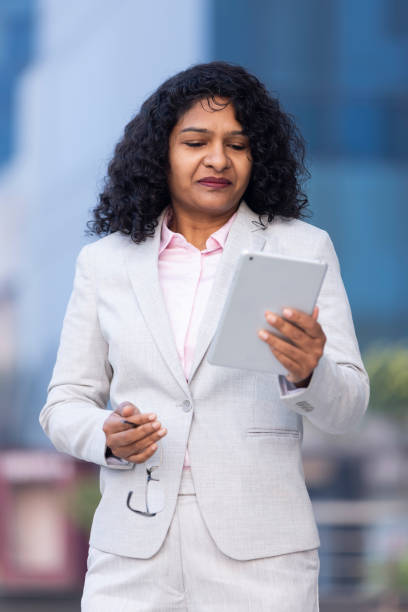 istock Successful businesswoman using digital tablet outside office building 1489668532