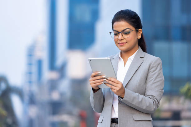 istock Businesswoman using digital tablet outside office building 1489668554