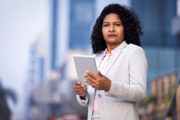 istock Businesswoman using digital tablet outside office building 1489669219