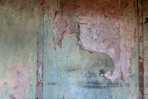 istock Antique wallpaper with rose pattern peeling off a wall 1489675230