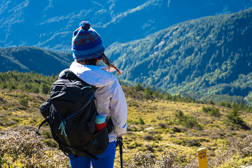 Hikers stand on top of a mountain looking at view.