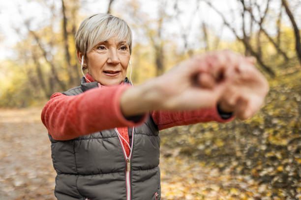 istock Senior woman in park stretching hands 1489695761