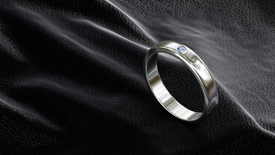 3D render of platinum ring design with blue diamonds on black leather background in studio lighting.