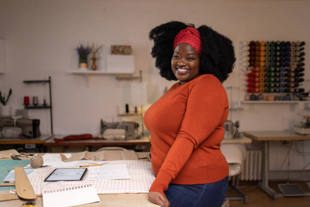 istock Happy black designer working on her sketches in a clothing design studio. 1489700929