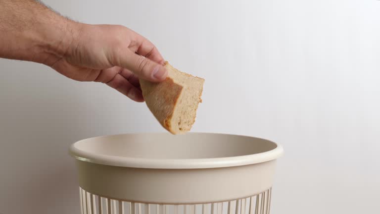 Stale bread with an expired shelf life is thrown into the trash for disposal and recycling.  The concept of utilization and processing of waste.