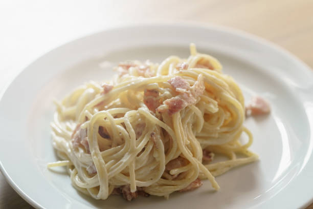 Top view of plate with spaghetti with mushrooms and bacon