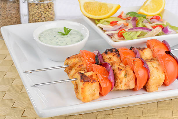 istock Cheese kebabs on metal skewers on white plate 148971002