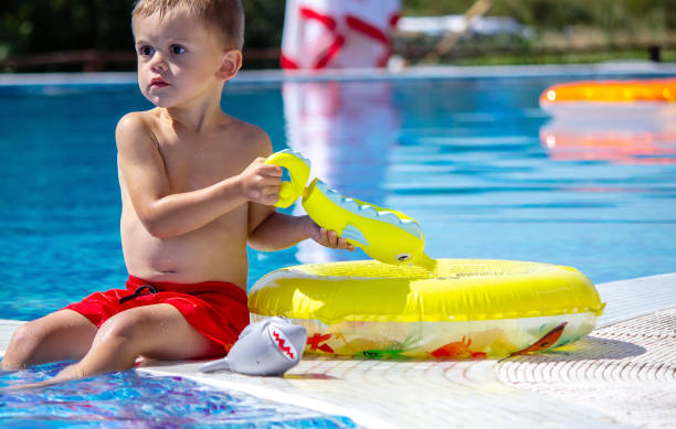 istock Happy child in the pool playing with a water gun. 1489713928