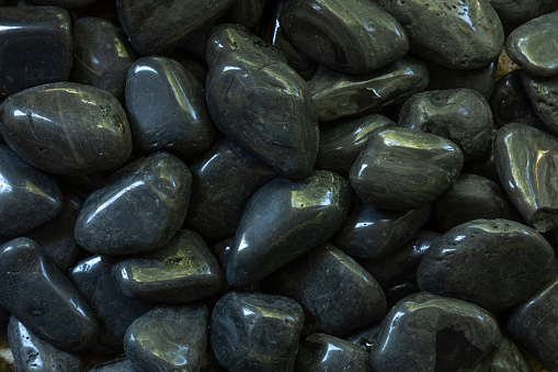 Closeup of black river pebbles seen from above