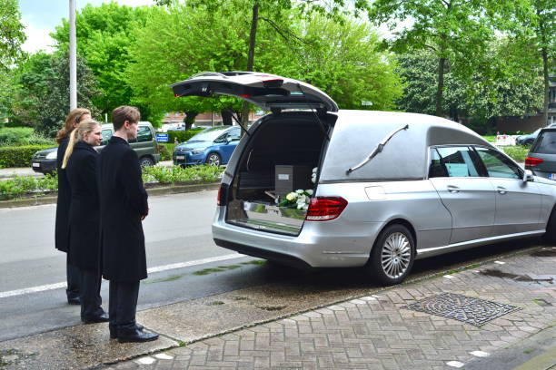 Berchem, province Antwerp, Belgium - May 12, 2023: 3 ceremonial funeral attendants waiting for the family coming out of the Catholic church to transport deceased male person to the cimetery
