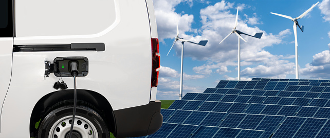 Electric van on a background of solar panel and wind turbines.