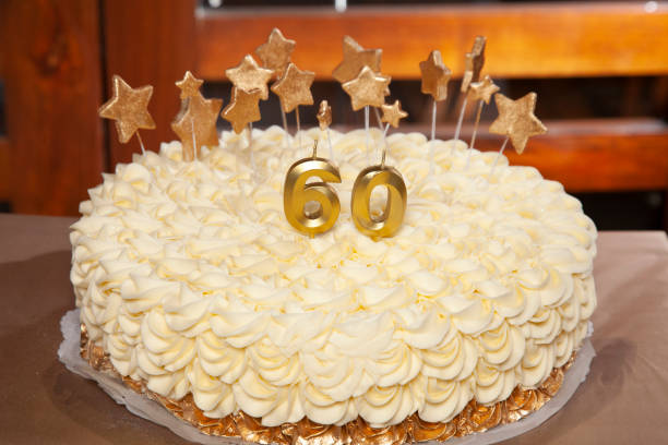 Beautiful white two-tiered cake decorated with flowers and golden cream. 50th Anniversary Cake.