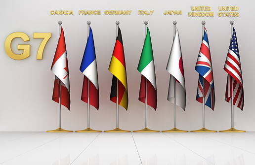 G7 table flags, 3d render. Flags of Group of Seven around podium, countries:  Canada, France, Germany, Italy, Japan, the United Kingdom, USA.