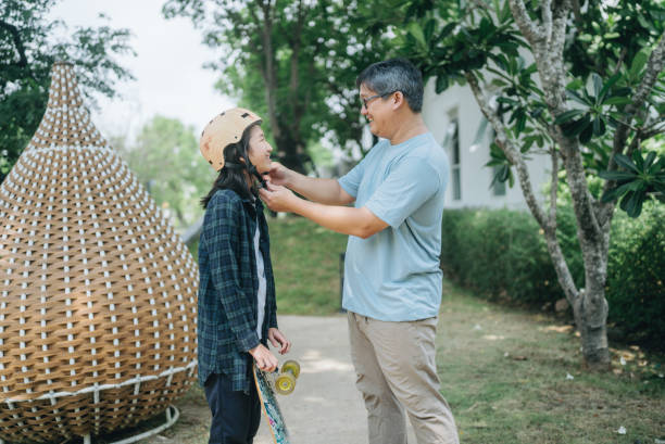 istock Asian father and daughter playing with roller skate having fun in the park 1489748347