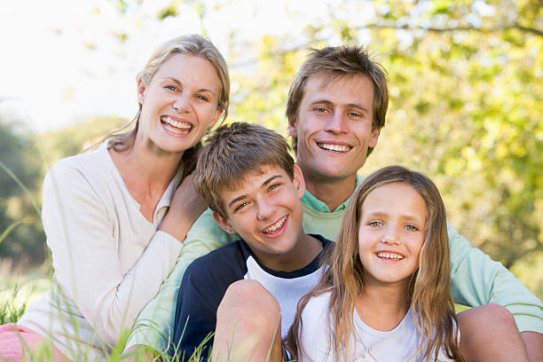 istock Family sitting outdoors smiling 148974964