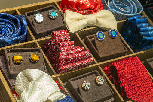 Cufflinks, ties and bow ties in a wooden box