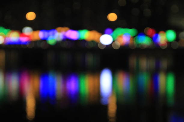 Water reflection of light at night with bokeh effect. Colorful blurred light at night reflected on water. Defocus effect. Travel and night scene, for background use.