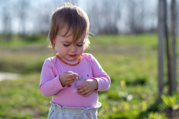 a little baby is playing with flowers in the meadow