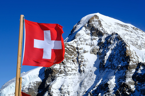 Schweizer Fahne auf dem Jungfraujoch, im Hintergrund der Gipfel des Eiger (3.967m)