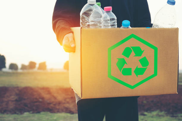istock A man collecting garbage and holding a recycle bin with plastic bottles with nature scene 1489760694