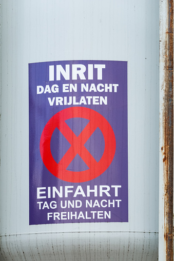 Warning sign in both the German and the Dutch language on a building site in The Netherlands. The sign reads: do not block the entry of the construction site, not in daytime and not in nighttime.