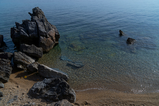 Old Greek village with rocks trees on the shore of the Aegean sea in Greece