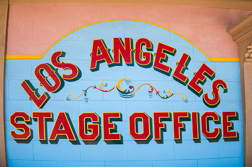 Colorful sign with the words Los Angeles Stage Office on the side of a building.