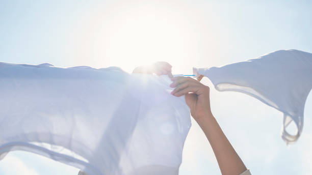 Woman hands hangs laundry on clothesline