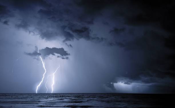 istock Dramatic image of a thunderstorm, the lightning illuminating the dark clouds over the ocean 1489781664