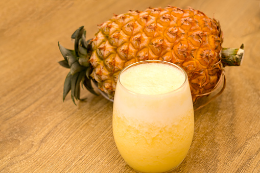 glass cup with pineapple juice and mint on a slate surface.