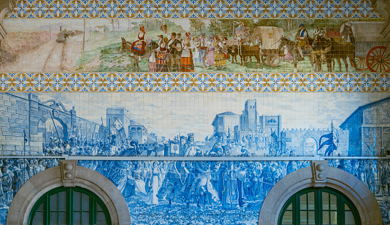 Porto, Portugal - April 19, 2023: The  azulejos (traditional ceramic tiles painted in the typical blue color) of the St. Bento Train Station