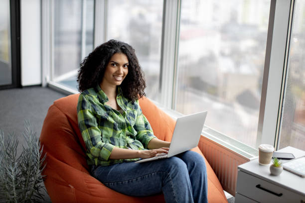 istock Businesswoman posing in beanbag with laptop at work 1489786412