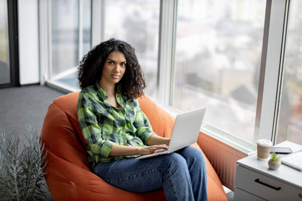 istock Businesswoman posing in beanbag with laptop at work 1489786429